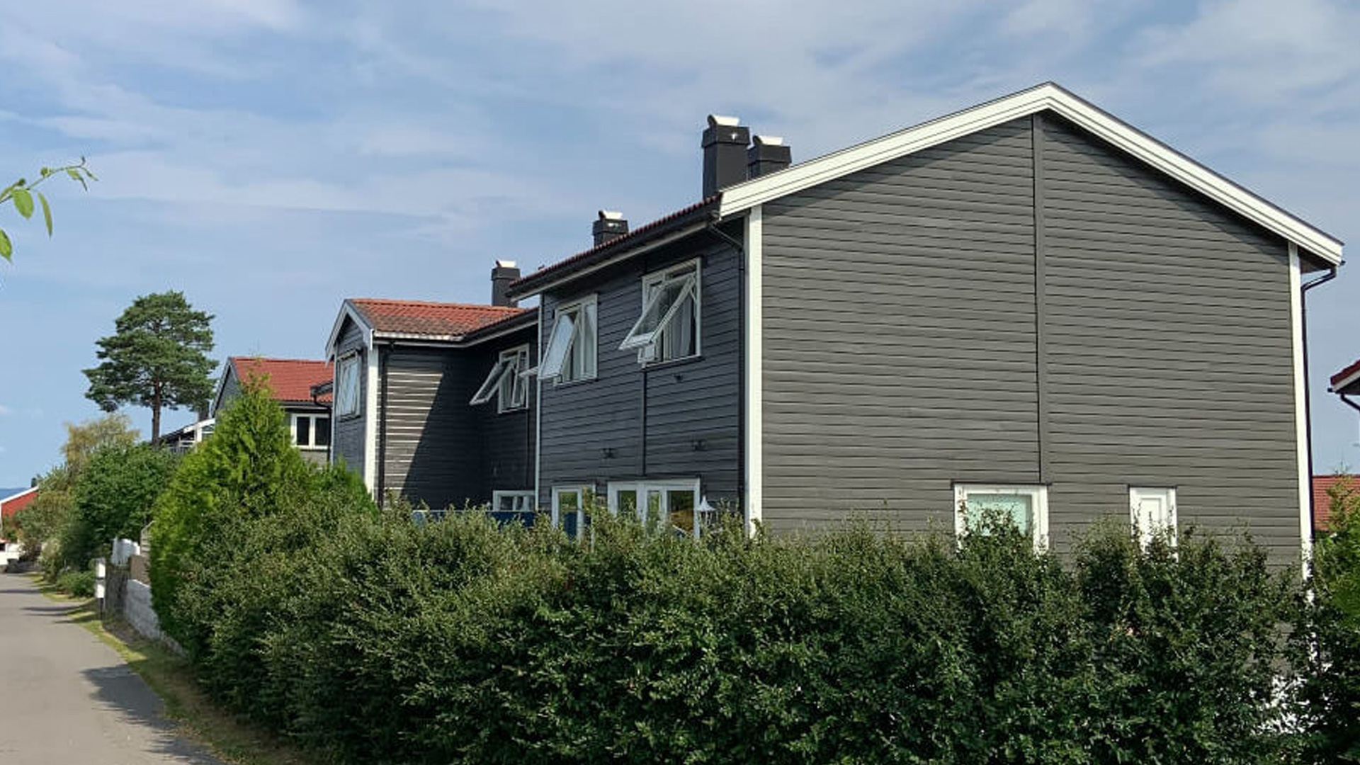 Bilde av rekkehus med gråmalt fasade i Preståsen Borettslag
